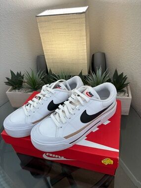 Nike White Low-Top Sneakers with Black Swoosh and Tan Accent